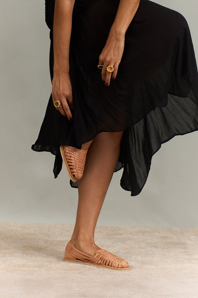 Mujer con huaraches mexicanos artesanales color nude y vestido negro